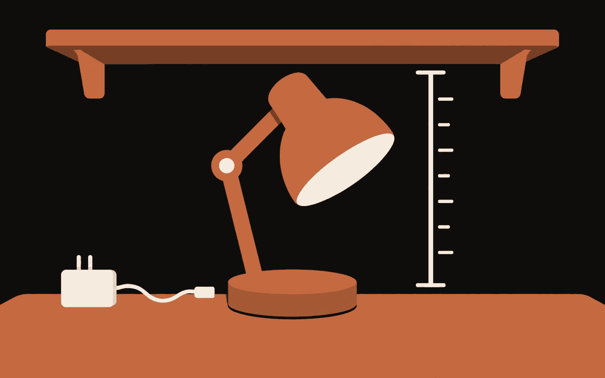 A terracotta desk lamp sits beneath a shelf beside a height gauge and a separate power adapter.